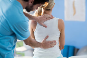 Cold Therapy in New Jersey - medical man with hands on patient back woman